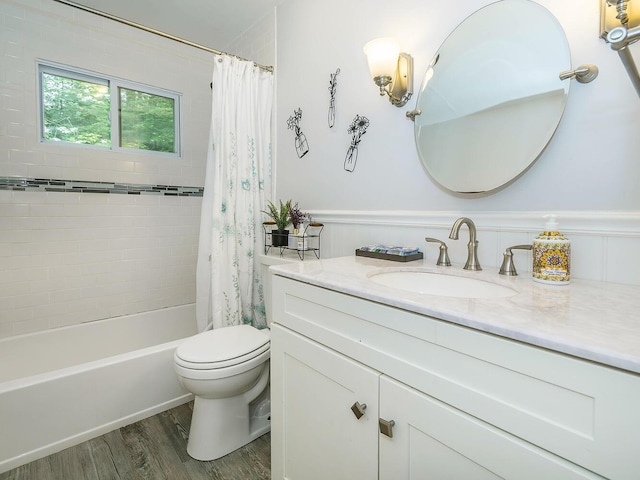bathroom featuring shower / bath combination with curtain, toilet, wood finished floors, a wainscoted wall, and vanity
