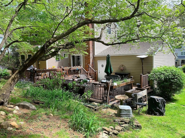 back of house featuring a deck and a shingled roof