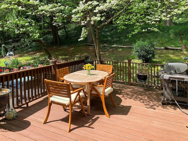 wooden terrace with grilling area and outdoor dining space