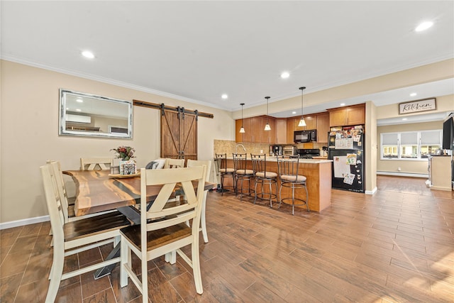 dining room with crown molding, a barn door, baseboards, and recessed lighting