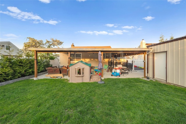 back of property featuring a fenced backyard, a patio, a chimney, and a lawn