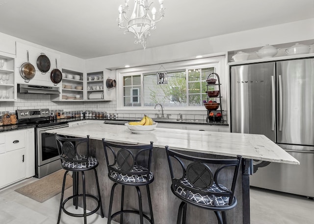 119 W Hunns Lake Rd, Stanfordville, NY 12581 - kitchen with stainless steel appliances, open shelves, under cabinet range hood, decorative backsplash, and dark stone counters