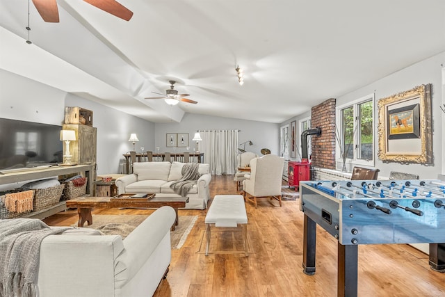 119 W Hunns Lake Rd, Stanfordville, NY 12581 - living room featuring a ceiling fan, a wood stove, light wood finished floors, and vaulted ceiling