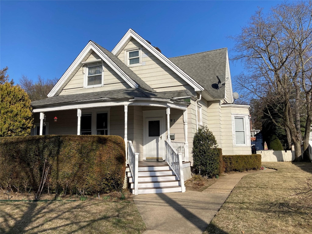 view of front of house with roof with shingles and a porch