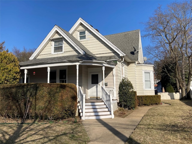 view of front of house with roof with shingles and a porch
