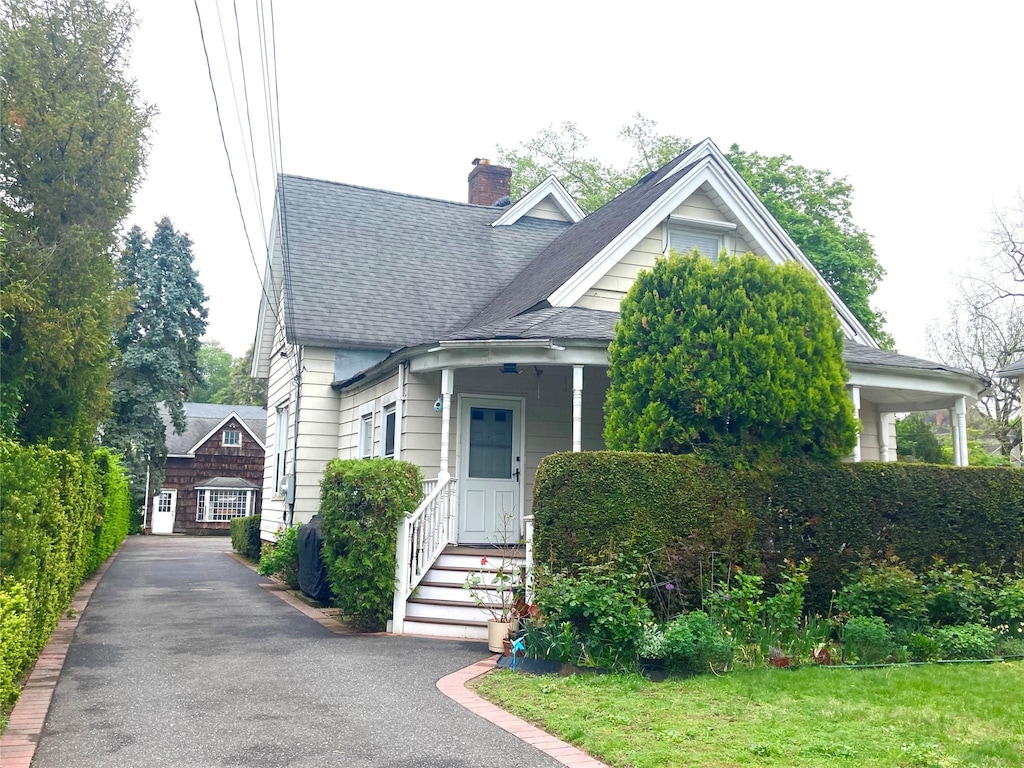 view of front of house featuring a shingled roof and a chimney