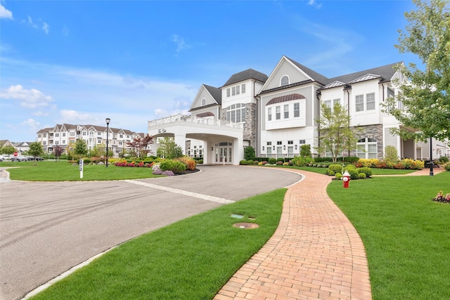 17101 Aspenwood Dr, Plainview, NY 11803 - view of front of property featuring a front lawn, curved driveway, french doors, and stone siding