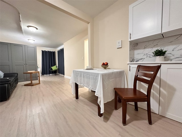 recreation room with baseboards and light wood-style flooring