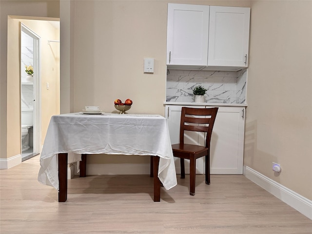 dining space featuring baseboards and light wood-type flooring