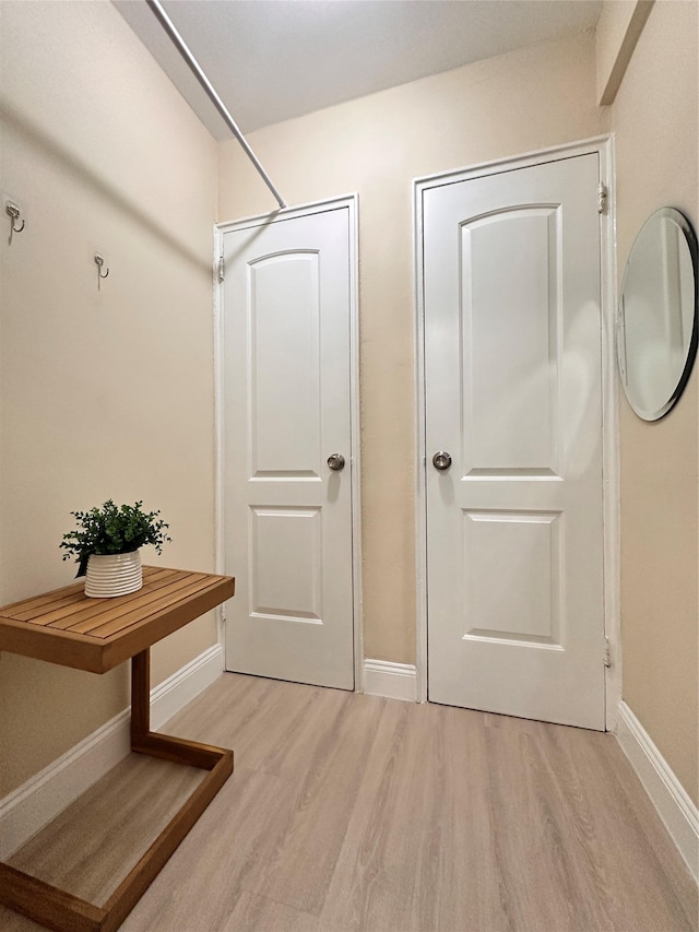 mudroom with light wood-style floors and baseboards