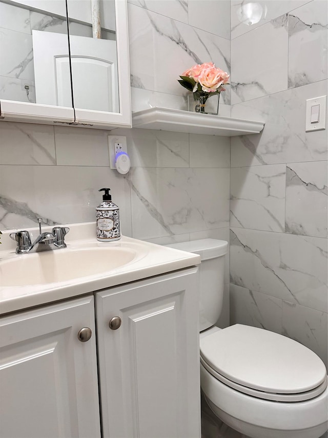 bathroom with vanity, tile walls, backsplash, and toilet