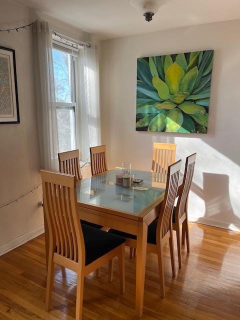 dining space featuring wood finished floors and baseboards