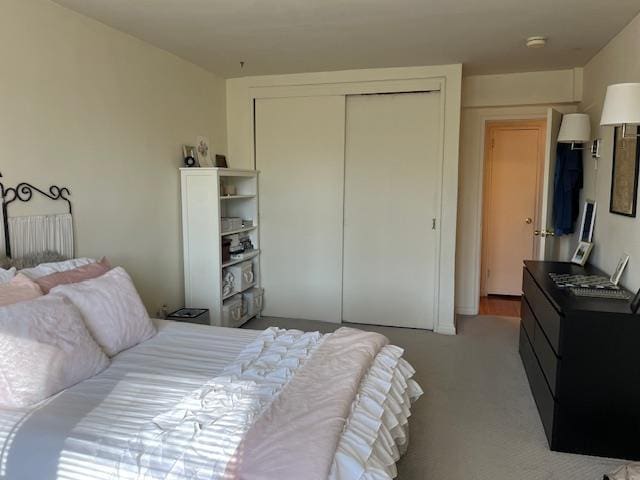 bedroom featuring light carpet and a closet