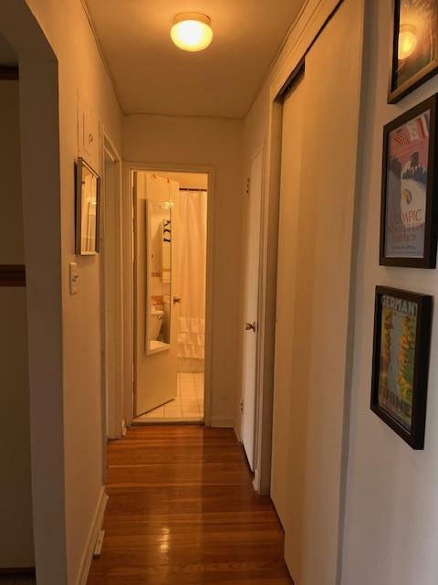 hallway featuring wood finished floors and baseboards