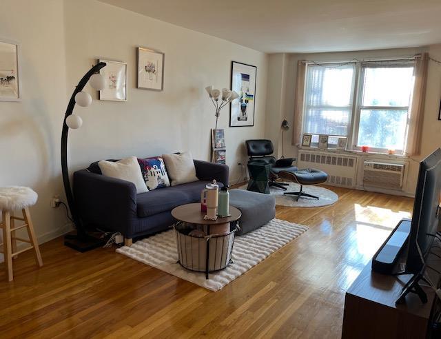 living room featuring wood finished floors and radiator heating unit