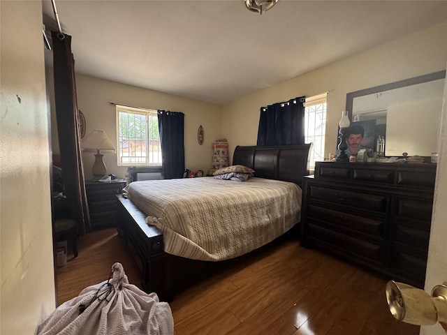 bedroom with dark wood-style flooring