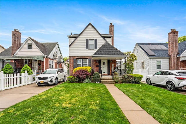 bungalow-style house featuring a front lawn, brick siding, and fence