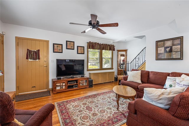 living room with stairway, ceiling fan, and wood finished floors