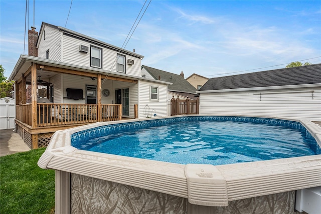 view of swimming pool with fence, a fenced in pool, and a wall unit AC