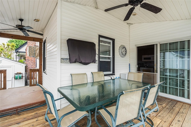 wooden terrace with outdoor dining area and a ceiling fan