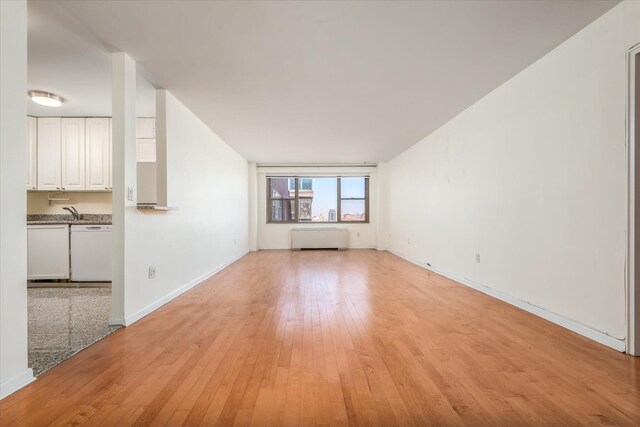 70-20 108th St Unit 15A, Forest Hills, NY 11375 - unfurnished living room with light wood finished floors and baseboards
