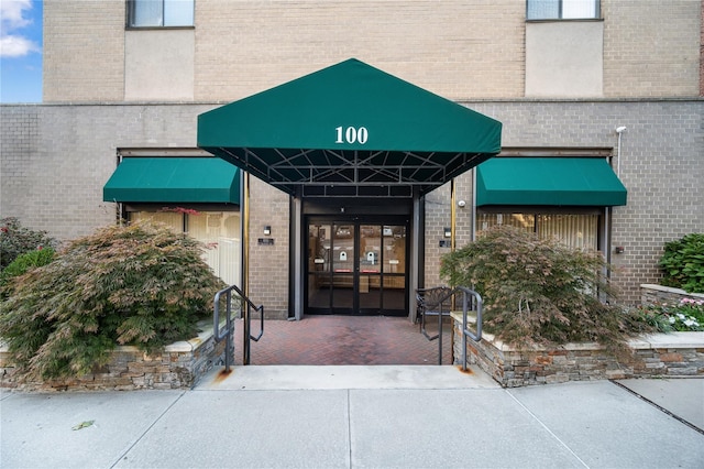 entrance to property featuring brick siding