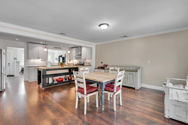 dining room featuring baseboards, dark wood-style flooring, ornamental molding, and visible vents