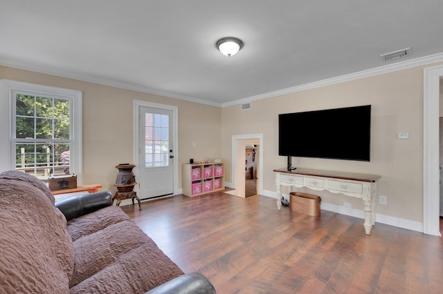 living room featuring crown molding, baseboards, visible vents, and wood finished floors
