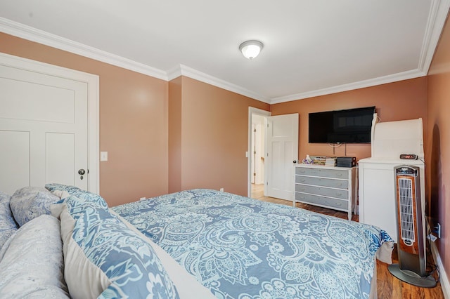 bedroom with crown molding and wood finished floors