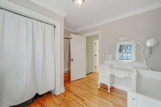 unfurnished bedroom with ornamental molding and light wood-style flooring