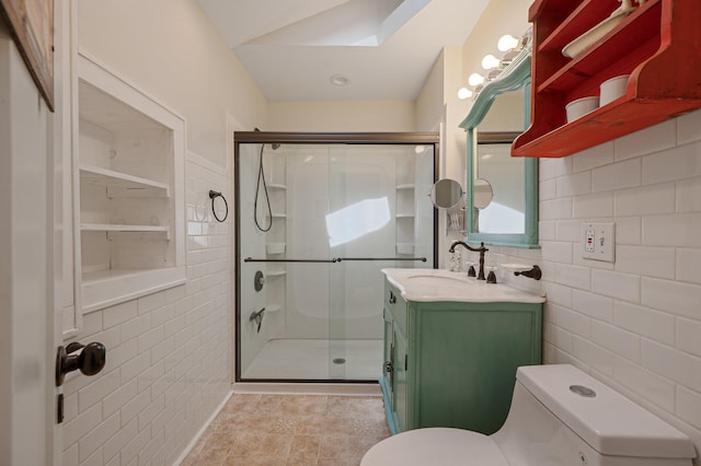 bathroom featuring tile walls, toilet, a shower stall, and vanity