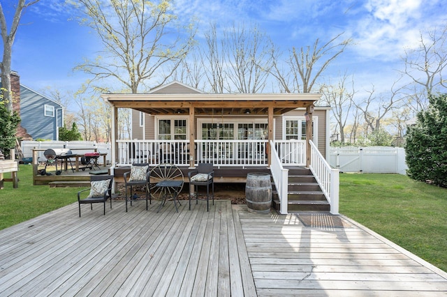 back of property with a yard, outdoor dining space, a wooden deck, and fence