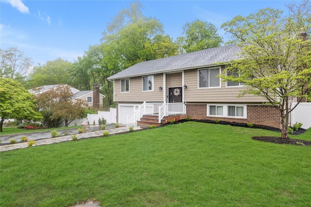 bi-level home with an attached garage, roof with shingles, and driveway