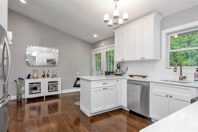 kitchen featuring appliances with stainless steel finishes, a sink, lofted ceiling, a peninsula, and light countertops