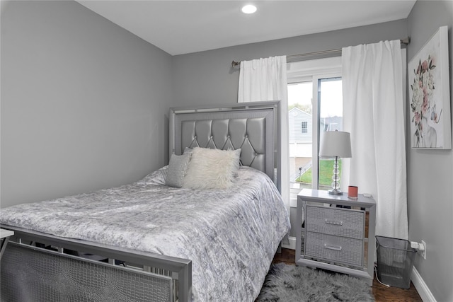 bedroom featuring baseboards, wood finished floors, and recessed lighting