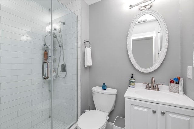 bathroom with a stall shower, toilet, and vanity