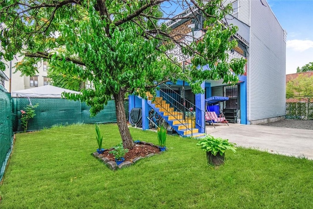view of yard with a fenced backyard and stairs
