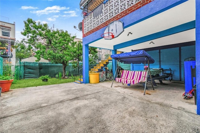 view of patio / terrace featuring stairway and fence