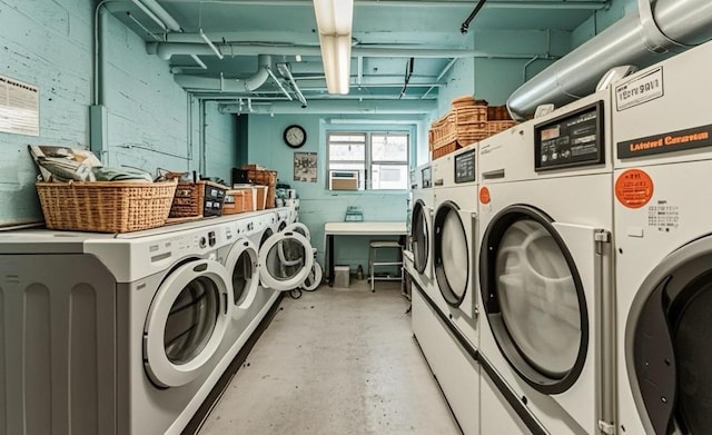 community laundry room with separate washer and dryer and concrete block wall