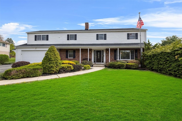 216 Maple Ave, Monroe, NY 10950 - view of front of home with a front yard, an attached garage, a chimney, brick siding, and driveway