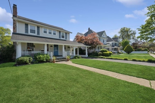 view of front facade with a front lawn, a chimney, and covered porch