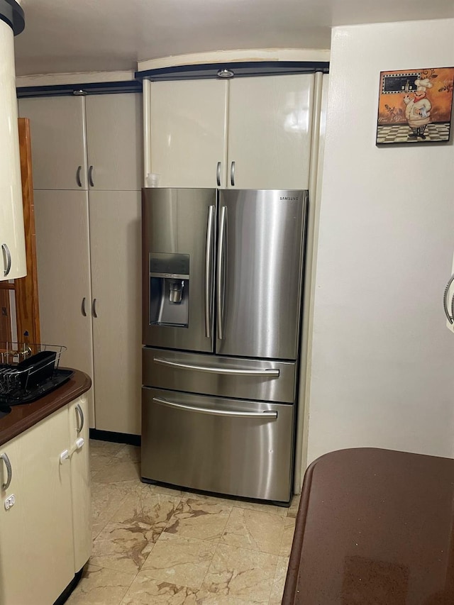 8340 Austin St Unit 5G, Kew Gardens, NY 11415 - kitchen with stainless steel fridge with ice dispenser, dark countertops, light marble finish floors, and water heater