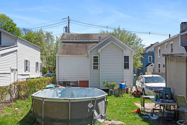 back of property featuring a yard and fence