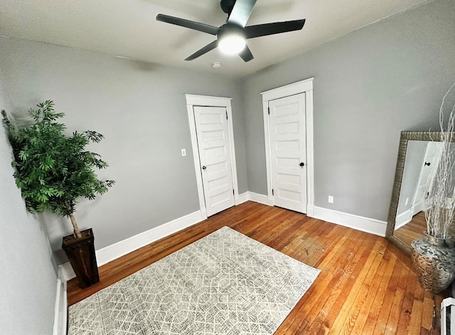 entrance foyer with ceiling fan, baseboards, and hardwood / wood-style floors