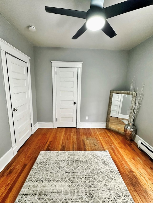 unfurnished bedroom featuring a ceiling fan, wood finished floors, and baseboards