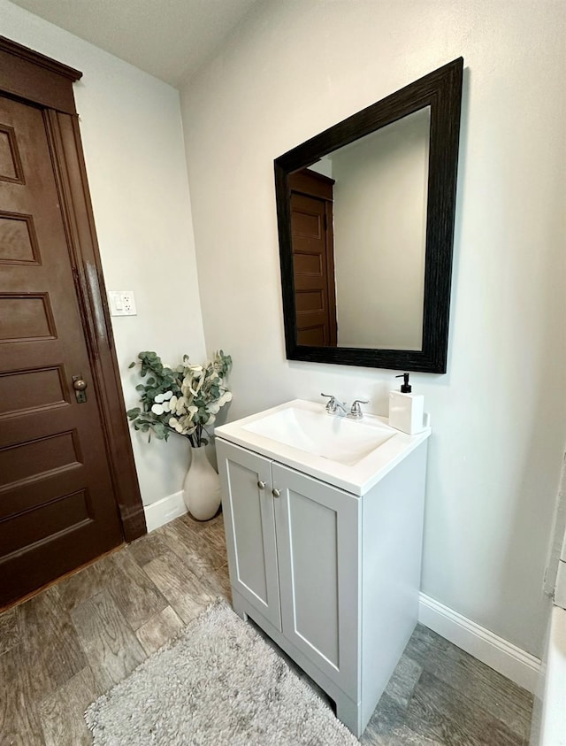 bathroom featuring baseboards, vanity, and wood finished floors