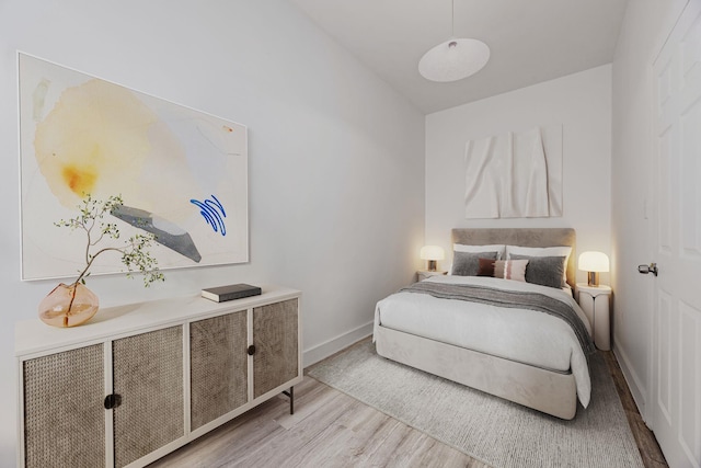 bedroom with baseboards and wood finished floors