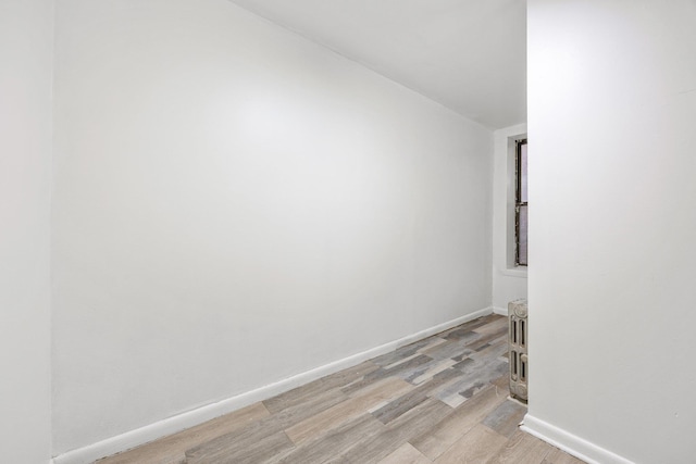 spare room featuring light wood-type flooring and baseboards