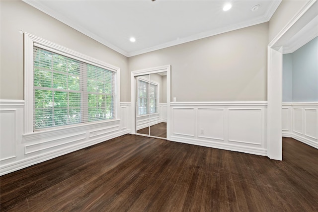unfurnished room with a wainscoted wall, dark wood finished floors, ornamental molding, recessed lighting, and a decorative wall