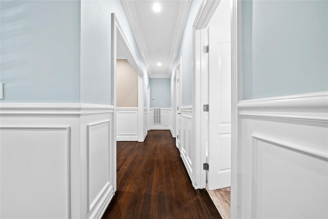 hall with a decorative wall, crown molding, wood finished floors, a wainscoted wall, and recessed lighting